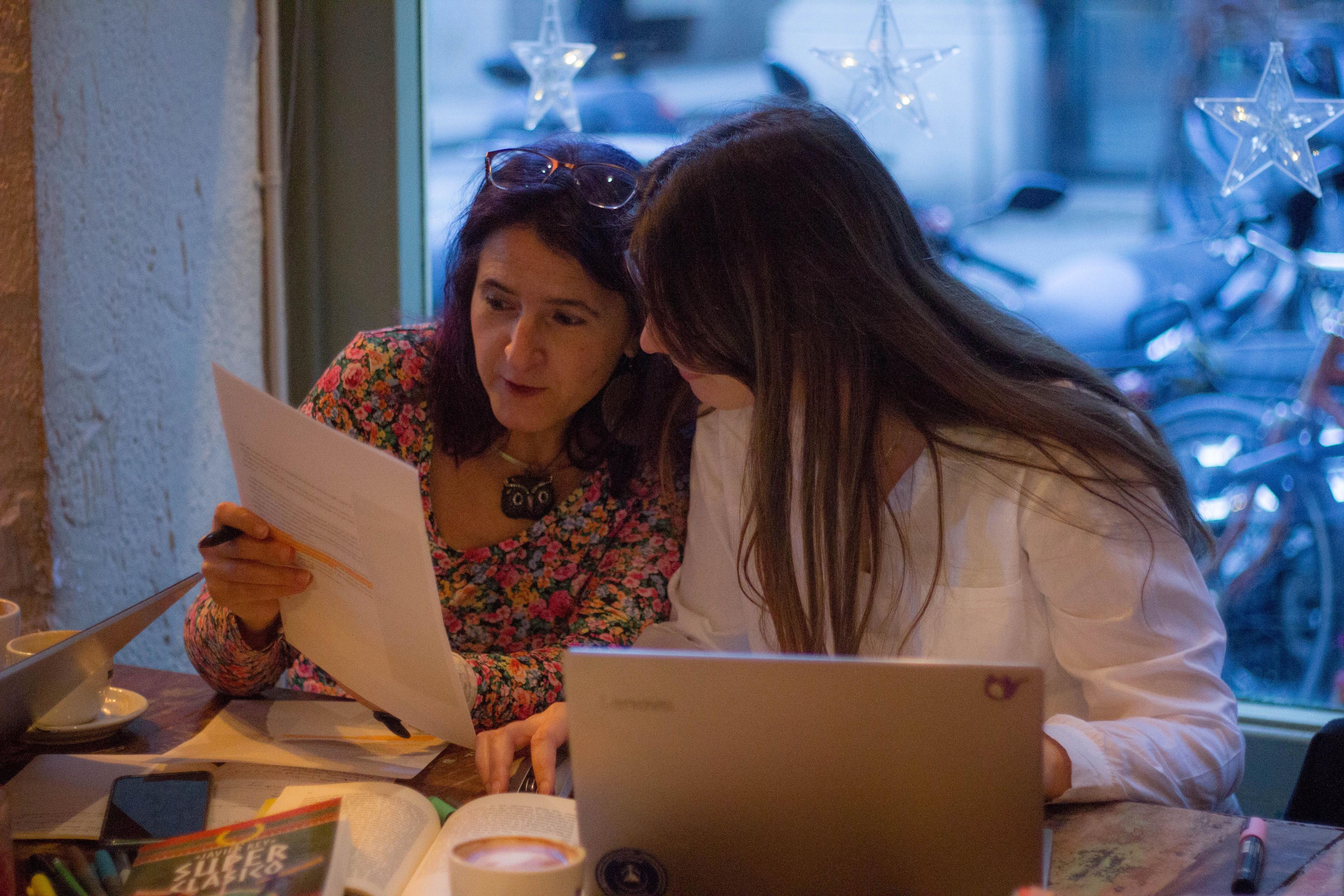 Foto que muestra a Maui Barone y Erika Cosenza trabajando con una portátil y hojas de papel.