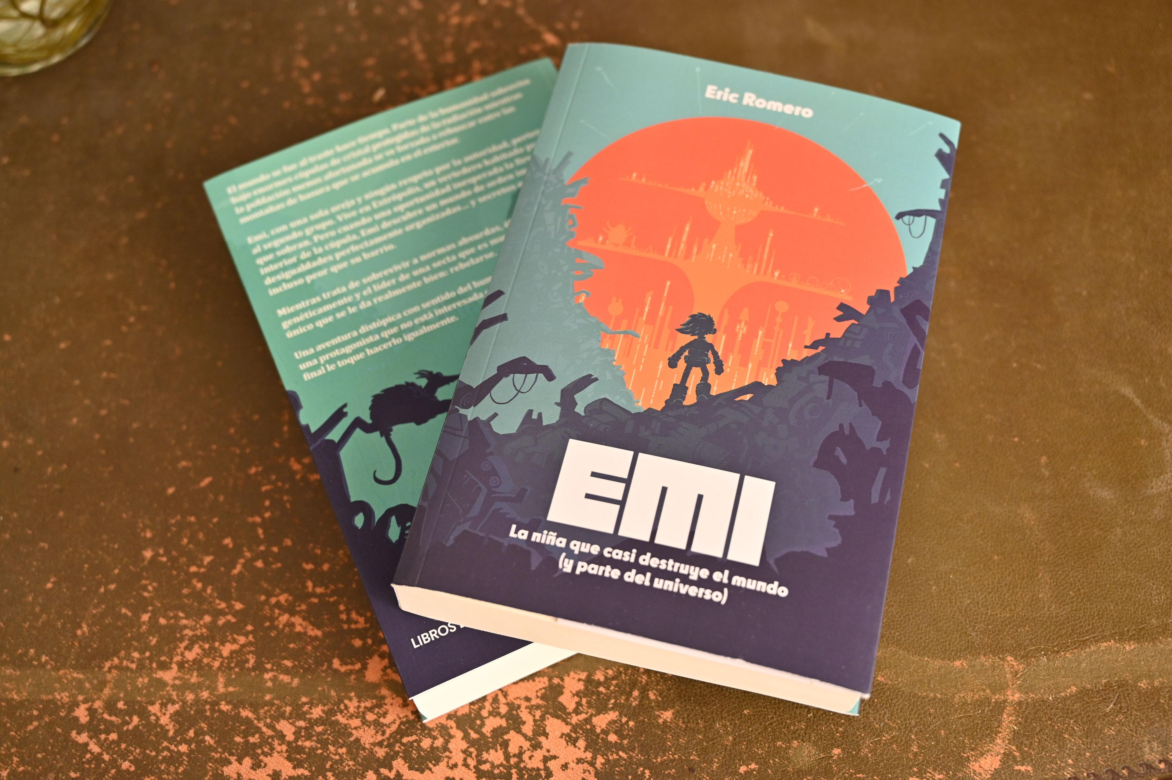 Una foto con dos ejemplares de «Emi, la niña que casi destruye el mundo (y parte del universo)»